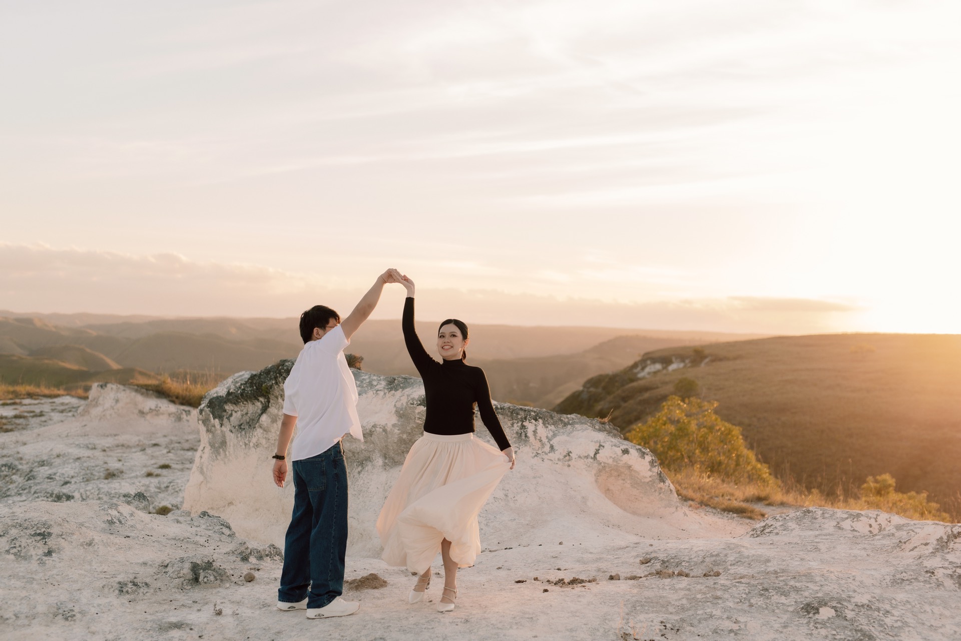 Rey twirling Feli on a white hilltop as the sun sets