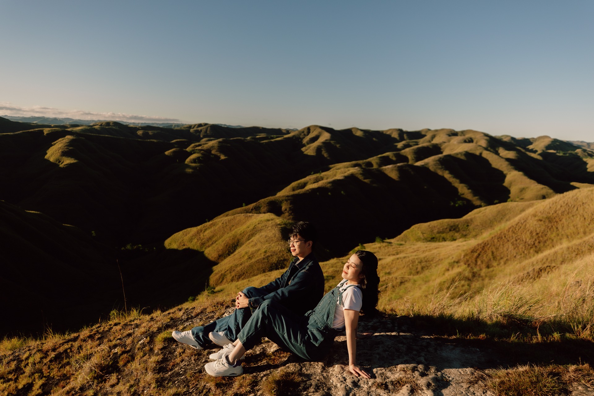 Rey and Feli sitting together on a golden hillside
