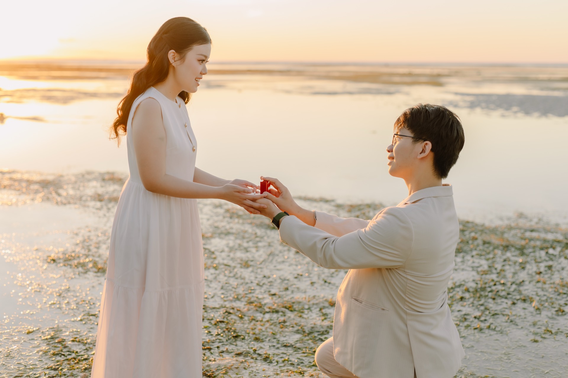 Rey proposing to Feli on the beach in the golden sunset light